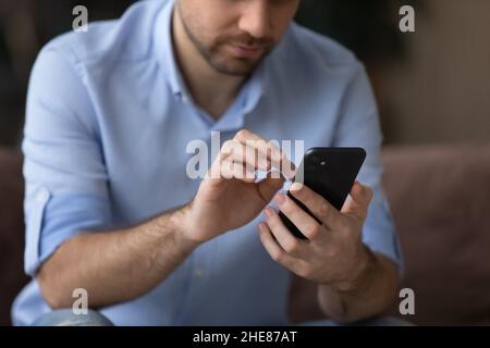 Cropped close up man using smartphone, typing on screen Stock Photo