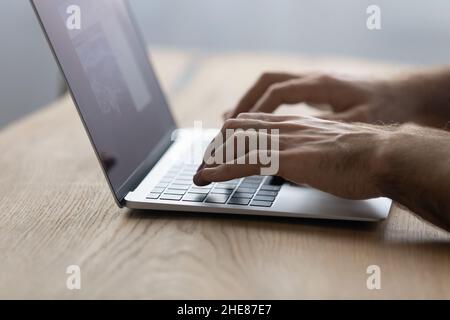 Crop close up male hands typing on laptop keyboard Stock Photo
