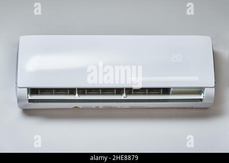 Adjusting temperature on air conditioner, Working air conditioner for comfort temperature in home at hot summer, cooling air in the room Stock Photo