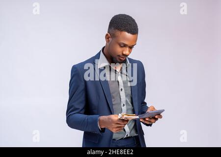 handsome man isolated over white background holding bank note and calulator Stock Photo