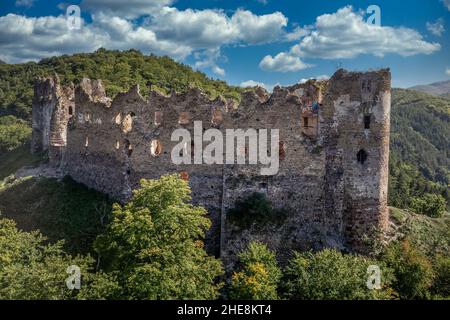 Aerial view of under restoration medieval Sasovsky castle above the Hron (Garam) river in Slovakia with circular gate tower, ruined gothic palace blue Stock Photo