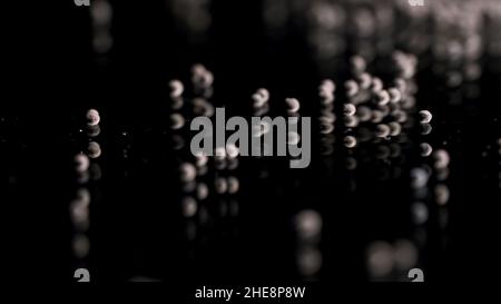 Close up of tiny gravel pile left on reflective black surface. Small stones at the laboratory during quality control of contruction materials process. Stock Photo