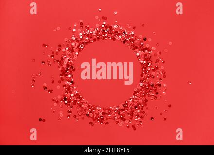 Sequins red confetti lined in round frame red background. Abstract festive composition place for text Stock Photo
