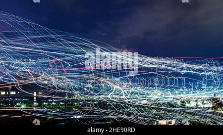 Abstract background consisting of night lights, bright white and red lines on a blue background Stock Photo