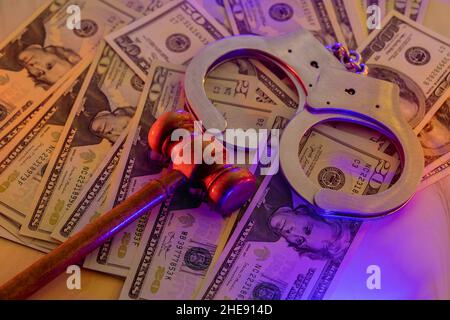 Wooden judge gavel with handcuffs US dollar bills in light flashes police Stock Photo