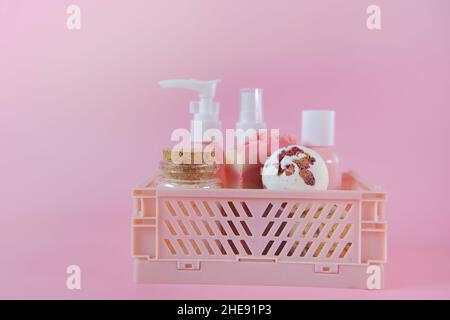 rose extract cosmetics.Bath bombs with rose petals,Pink cosmetic bottles in a box on a pink background.Beauty and aromatherapy.  Stock Photo