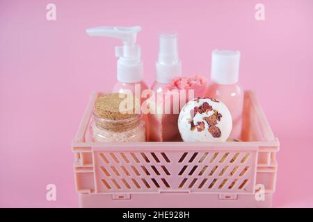 rose extract cosmetics.Bath bombs with rose petals,Pink cosmetic bottles in a box on a pink background. Stock Photo