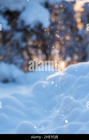 Ice crystals floating in the air and glittering in sunlight, cold winter day, defocused bokeh background. Stock Photo
