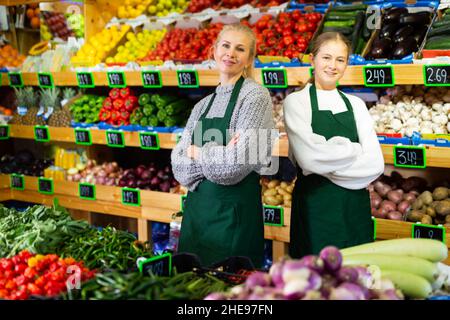 Girl helping her mother work as a salesman in a grocery store Stock Photo