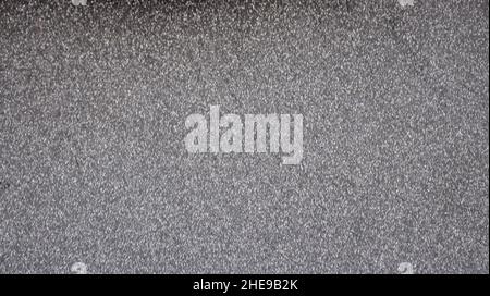 Monochrome black surface with a scattering of small silvery blotches with a blurred background. Background, pattern, texture. Stock Photo