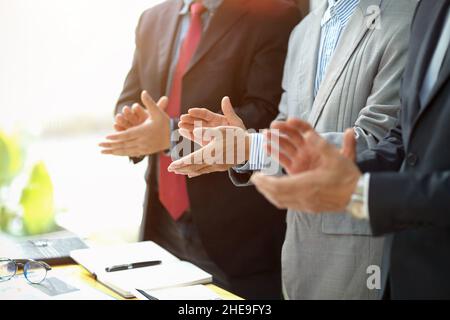 Group of a executive businessman standing and clapping theirs hands in the meeting room. congratulations, successful gesture Stock Photo
