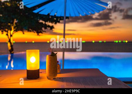 Sunset at the edge of a swimming pool at Kata beach in Phuket province, in Thailand Stock Photo