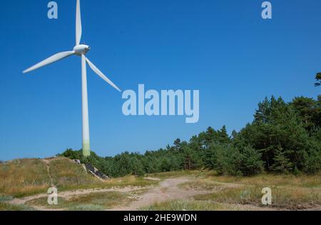 Windmill for electricity generation in the forest in Liepaja Stock Photo