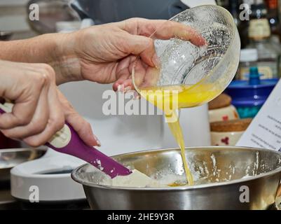 Cook puts the egg yolks in the pie bowl Stock Photo