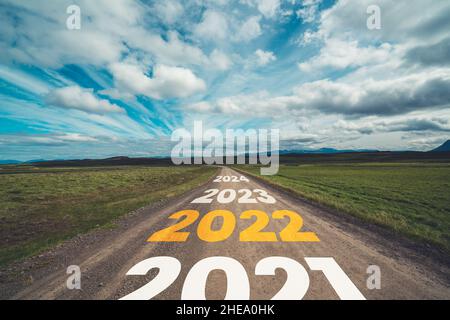 2022 New Year road trip travel and future vision concept . Nature landscape with highway road leading forward to happy new year celebration in the Stock Photo