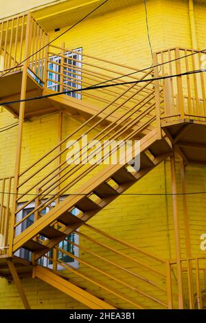 Yellow metal staircase and brick wall building Stock Photo