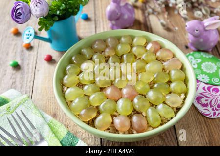 Holiday food, easter salad. Salad with chicken, cheese, walnuts and grapes on a festive table. Stock Photo
