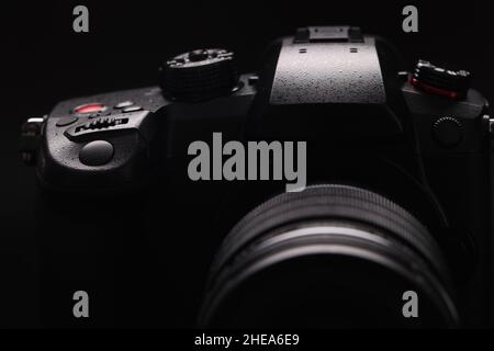 Digital stylish black camera on a black background, close-up Stock Photo