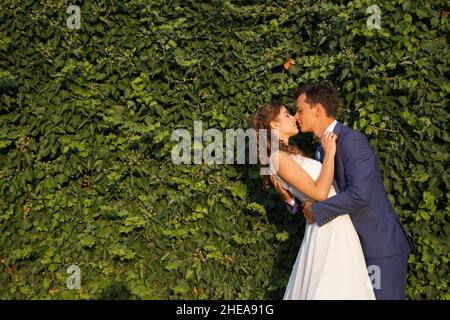 Cute wedding couple in ukrainian traditional clothes sitting on the bench in the town and spending time together Stock Photo