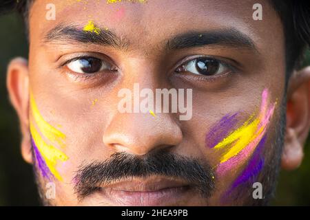 Close up of a young Indian man's eyes covered in colored dye at Holi festival in West bengal, India. Stock Photo