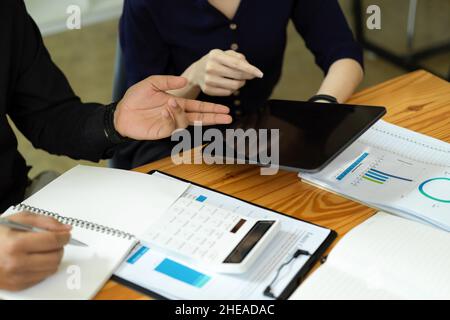Businesswoman giving some new ideas about project to her partners in conference room. Business people discussing on the financial plans. Stock Photo
