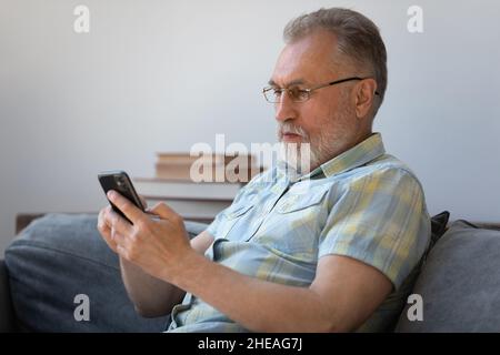 Happy middle aged man using cellphone apps. Stock Photo
