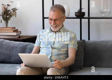 Happy middle aged man using computer apps. Stock Photo