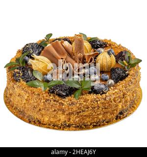 Festive cake with nuts and salted caramel topping decorated with dried pune isolated on white background Stock Photo