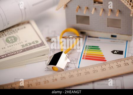 A model home and house key on architectural floor plans. Close up Stock Photo