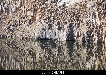 Basaltic rock formations and the so called emerald lake in the transylvanian town of Racos, Romania, on a sunny autumn day. Stock Photo