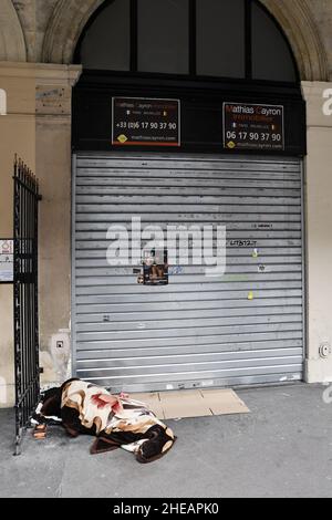 Homeless sleeping in front of a closed store by COVID Crisis and traffic difficulties of circulation - Rue de Rivoli - Paris - France Stock Photo