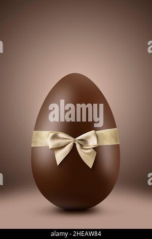 Chocolate easter egg with gold ribbon on brown background Stock Photo