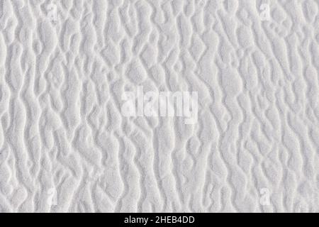 Various shapes in white sand. Abstract irregular texture on beach. Summer background. Holiday at sea concept. Stock Photo