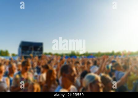 People watching music concert on large stage. Blurred image. Stock Photo