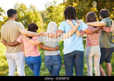 Multicultural group as a team and community side by side arm in arm in nature Stock Photo