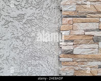 Part of the wall finished with decorative plaster and part with colored figured bricks Stock Photo