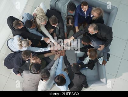 Diverse business people group put hands together in stack pile at training as concept of sales team corporate unity connection Stock Photo
