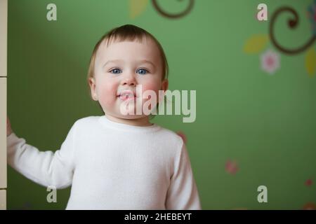 September 14, 2018. Belarus, the city of Gomil. Studio apartment photo. Little one-year-old girl looks at the camera and smiles.