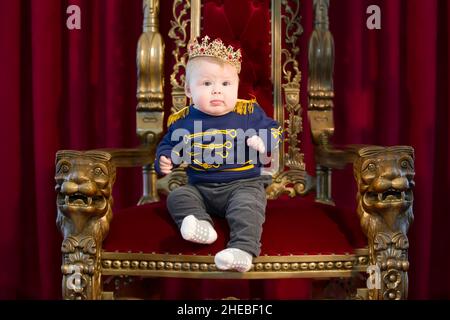 Belarus, the city of Gomel, January 02, 2019. Photo studio. Funny kid for the royal crown on the royal throne. Stock Photo