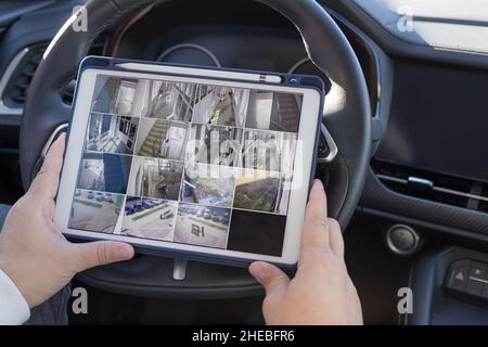 Man sitting in car and looking at monitoring cameras Stock Photo