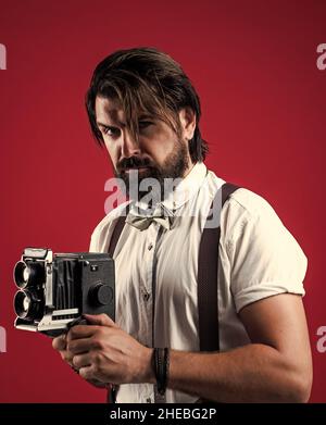 journalist with vintage photo camera. formal party reporter. old fashioned bearded hipster. retro man in suspenders and bow tie. confident elegant Stock Photo