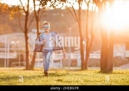 Caucasian boy with glasses walks through the autumn park. Copy space. Stock Photo