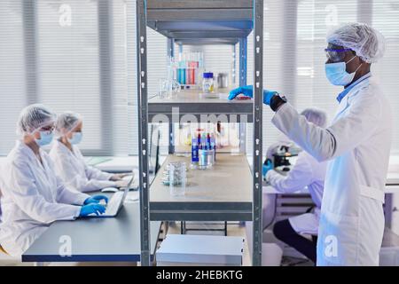 Group of doctors in protective wear working with analysis in test tubes in the hospital laboratory Stock Photo