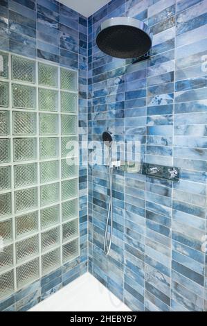 Blue tiled modern shower with a glass block back wall Stock Photo