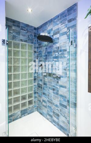 Blue tiled modern shower with a glass block back wall Stock Photo