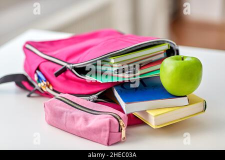 backpack, apple and school supplies on table Stock Photo