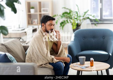 sick indian man using nasal spray at home Stock Photo
