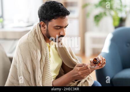 sick man pouring medication from bottle to spoon Stock Photo