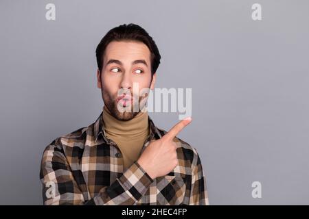 Photo of impressed funny guy dressed checkered shirt looking pointing empty space isolated grey color background Stock Photo
