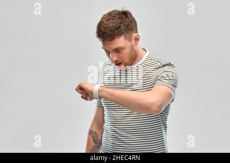 surprised young man looking at smart watch Stock Photo